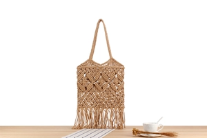 Detail of bohemian hand-woven beige cotton bag with diamond patterns and long tassels