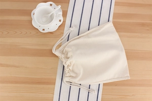 Detailed macro view of the cream cotton drawstring inner pouch and refined stitching