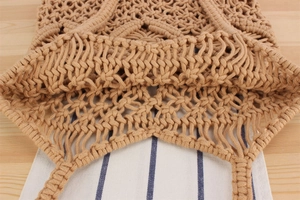Detailed close-up of bohemian hand-woven cotton rope mesh bag with hollow out pattern