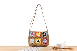 Detail of bohemian crochet floral crossbody bag made of colorful raffia woven squares