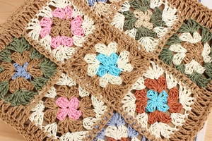 Close-up of handmade bohemian crochet bag with colorful floral knit patterns