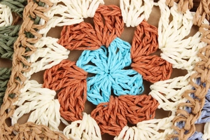 Detailed macro shot of handmade bohemian crochet pattern with colorful floral fiber weave