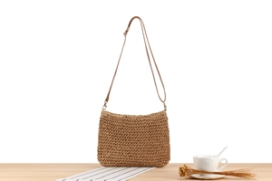 Detail of vintage flower crochet crossbody bag with leather strap on a wooden surface