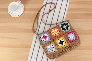 Detail of handmade crochet floral shoulder bag with colorful patterns and leather strap