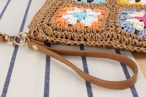 Dettaglio borsa vintage all'uncinetto con fiori, cinturino in pelle e gancio oro