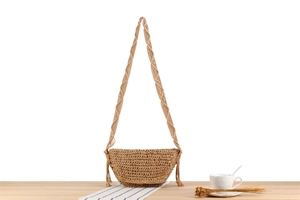 Detail of handmade khaki woven crossbody bag with braided strap and hanging tassels