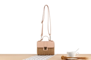 Détail du sac bandoulière tissé bicolore avec rabat en cuir rose et boucle métallique