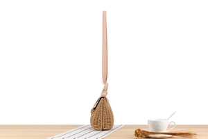 Détail du sac tressé bicolore avec bandoulière en cuir rose et fermoir en métal