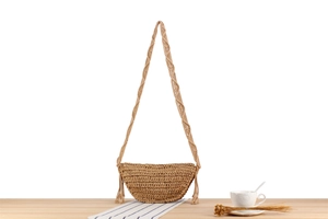 Detail of handmade khaki woven paper rope bag with stylish tassel and braided strap