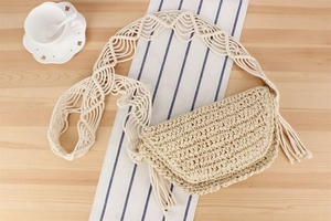 Detail of bohemian paper rope woven bag featuring fringe tassels and macrame strap