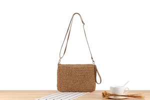 Dettaglio di una borsa a tracolla kaki in corda di carta tessuta a mano con cinturino in pelle