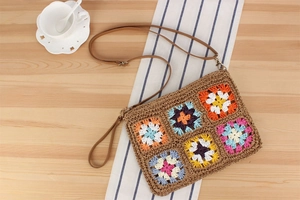 Dettaglio di motivi floreali all'uncinetto su una borsa boho intrecciata marrone