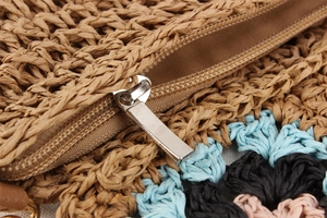 Dettaglio borsa in corda di carta intrecciata a mano con fiori boho e zip metallica