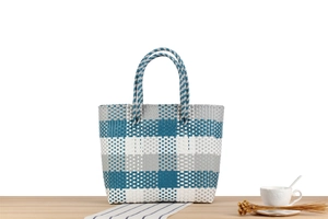 Dettaglio della borsa tote intrecciata a scacchi blu e bianchi su legno