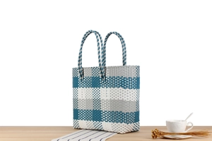 Dettaglio macro della trama intrecciata a scacchi blu e bianchi della borsa in plastica