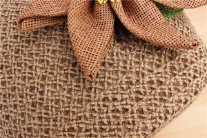 Dettaglio di borsa a spalla in paglia intrecciata con un grande ornamento floreale naturale