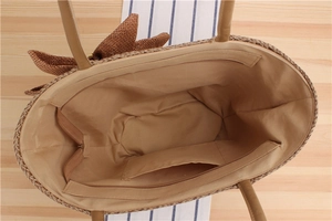 Vista dettagliata della borsa in paglia intrecciata con fodera beige e tasca interna