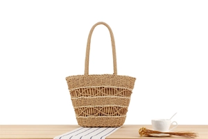 Macro shot of natural woven straw tote featuring openwork texture and round handle