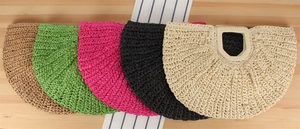 Flat lay of colorful woven half-moon handbags in khaki, green, pink, black and cream
