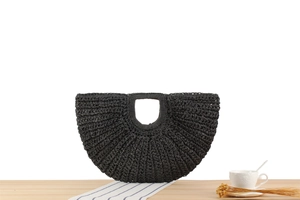 Detail of black woven crescent moon bag on wooden table with rustic coffee setting