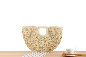 Detailed texture of bohemian hand-woven crescent bag on a minimalist wooden table