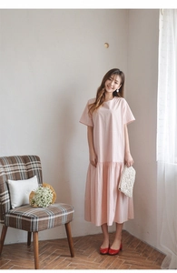 Pink short sleeve loose dress with ruffle hem paired with woven tassel clutch bag
