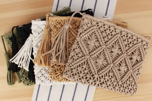 Detail showing five colors of macrame woven clutch bags with long tassels and wood background