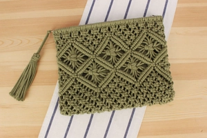 Detail of sage green handwoven tassel clutch with intricate diamond knit patterns