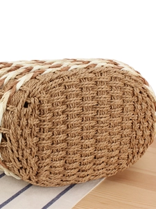 Bottom detail of a large capacity woven straw tote bag with intricate striped pattern