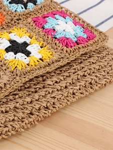 Handmade crochet crossbody bag with colorful bohemian flower patterns on brown paper rope