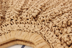 Macro detail of the reinforced handles and tight hand-woven texture on a moon-shaped bag