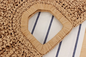 Detailed close-up of handmade woven straw bag featuring hexagonal handle and dense crochet texture
