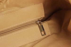 Close-up of brown inner lining with golden zipper pocket and neat stitching details