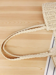 Handwoven bohemian straw tote bag with braided handles and fabric lining for beach travel