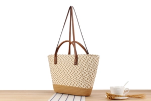 Detail of bohemian straw tote bag showing contrast weave texture and brown leather strap