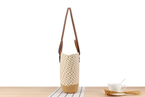 Detail of bohemian hand-woven tote bag with dual-tone texture and brown leather straps