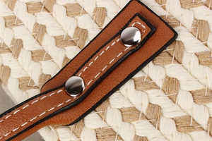 Detail of bohemian handwoven bag with brown faux leather strap and silver metal rivets