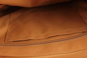 Detail of the brown canvas inner lining featuring a pocket and a matching zipper closure