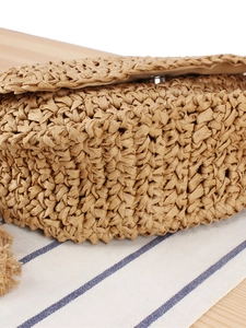 Handcrafted straw shoulder bag with woven paper texture and rustic lid close detail