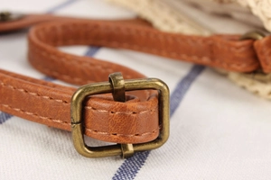 Detailed close-up of brown faux leather adjustable strap with vintage bronze buckle