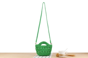 Détail du sac seau au crochet vert fait main avec motifs de tissage ajourés complexes