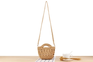 Gros plan détaillé d'un sac seau en crochet fait main posé sur une table en bois clair