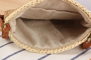 Detail of hand-woven straw bag showing inner linen lining and metal zipper closure