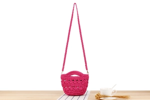 Détail du mini sac seau fuchsia avec motif tissé à la main et bandoulière texturée