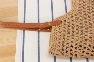 Gros plan du sac en corde de coton tissé main avec bandoulière en cuir et rivets