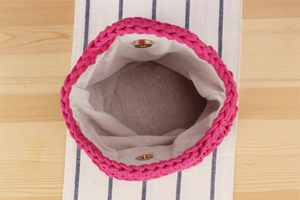 Détail d'un sac seau fuchsia tressé main avec fermoir magnétique et doublure coton