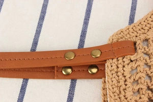 Détail de la texture crochetée kaki avec sangle en similicuir marron et rivets en bronze