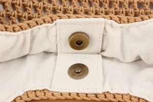Détail du sac tressé marron avec boucle magnétique en bronze et doublure beige doux