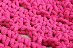Gros plan détaillé de la texture en corde de coton tressée rose rouge et motif ajouré