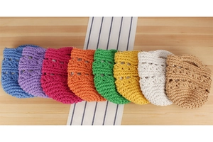 Vue de dessus de huit sacs seaux colorés en corde de coton tissé main sur table en bois